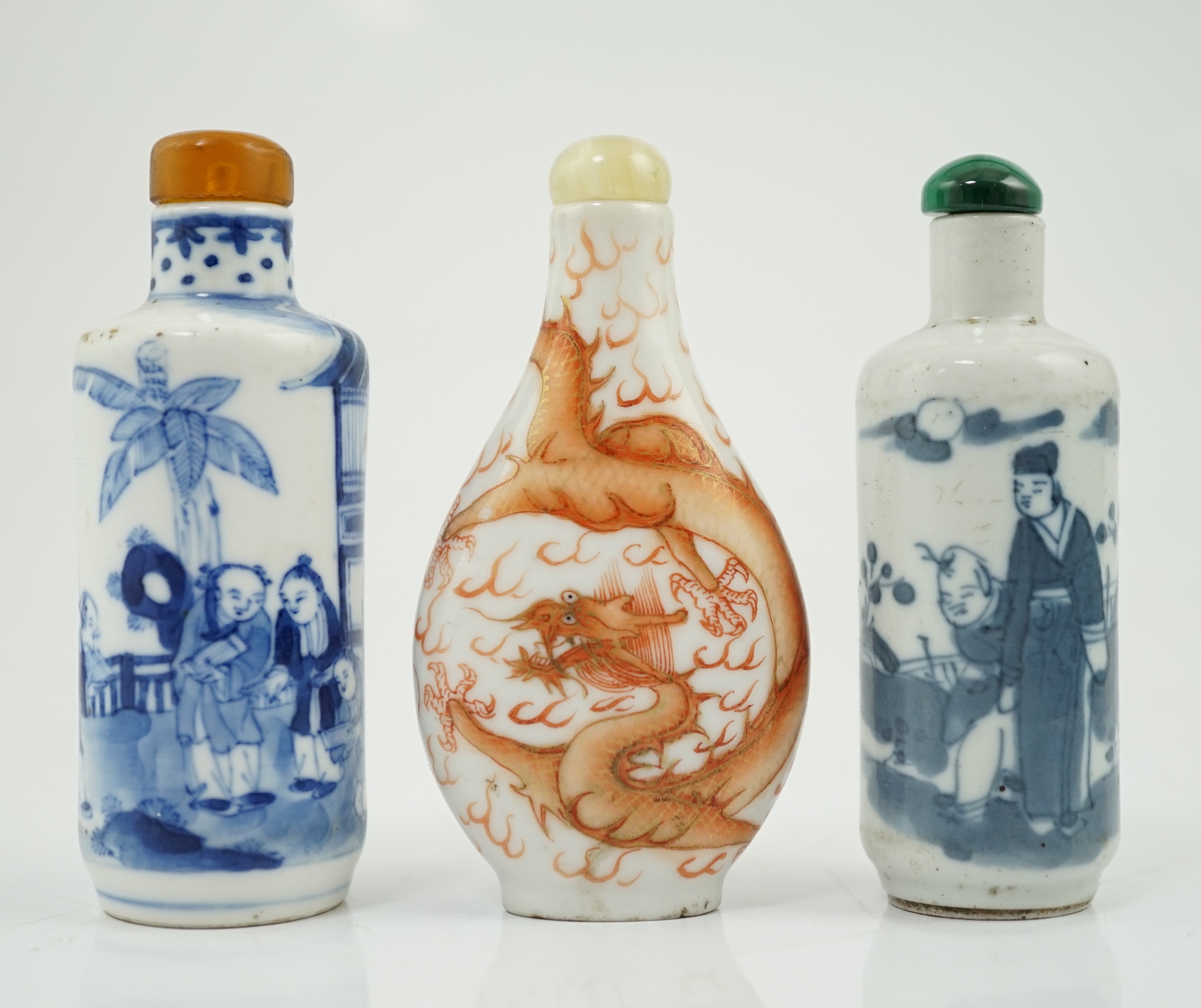 A Chinese iron red enamelled ‘dragon’ snuff bottle, Tongzhi mark and of the period (1862-74), together with two Chinese blue and white cylindrical snuff bottles, 19th century